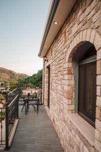 een balkon van een gebouw met een tafel en stoelen bij To Petrino (VIlla Markos) in Parga