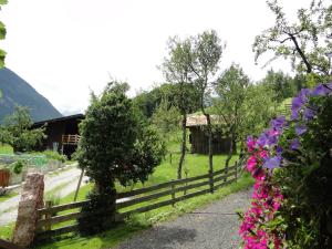 a fence with flowers in front of a building at Ferienzimmer Brennerbauer in Lofer