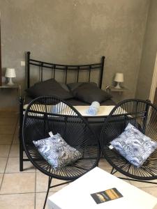 een slaapkamer met 2 stoelen en een bed bij Chez Anidé in Cannet