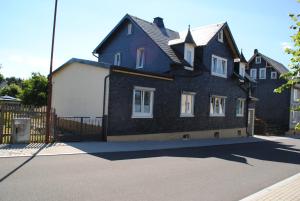 uma casa a preto e branco ao lado de uma cerca em Ferienwohnung „von Groppau“ em Böhlen