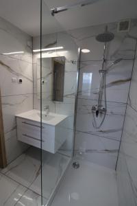 a bathroom with a glass shower and a sink at Gorce apartamenty i pokoje in Rabka-Zdrój +62 photos