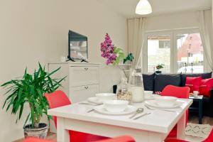 salon z białym stołem i czerwonymi krzesłami w obiekcie Apartament Giencyno Koncina Zakopane w Zakopanem +11 zdjęć
