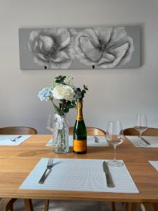 uma mesa com uma garrafa de vinho e um vaso de flores em Stunning New Townhouse in the Heart of Warwick em Warwick