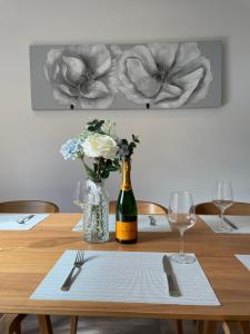 a table with a bottle of wine and a vase of flowers at Stunning New Townhouse in the Heart of Warwick in Warwick