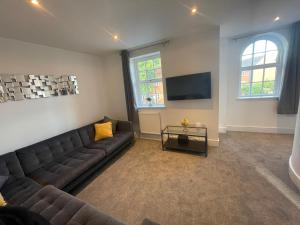 a living room with a couch and a tv at Stunning New Townhouse in the Heart of Warwick in Warwick