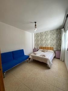 a bedroom with a bed and a blue couch at La Casa Grande in Benaocaz