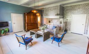 a living room with blue chairs and a couch at Juffertje in het groen in Zwolle