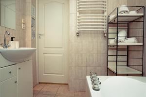 łazienka z umywalką i półką z ręcznikami w obiekcie Apartament Giencyno Koncina Zakopane w Zakopanem