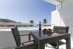 a table with a glass of wine and a plate of food at Apartamento Tobago - Puerto Rico in Puerto Rico de Gran Canaria