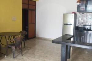 a kitchen with a table and chairs and a refrigerator at Park Grand Boutique 3 Bedroom Bungalow in Marmagao