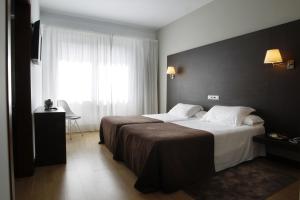En eller flere senge i et værelse på Hotel Mendez Nuñez