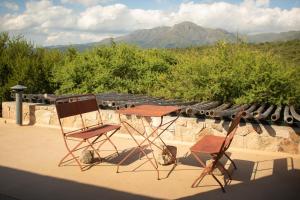 2 sillas y una mesa en la azotea en Costas del Cuniputu - Casa de Campo en Capilla del Monte