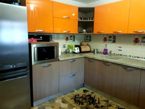une cuisine avec des armoires orange et un tapis de cuisine dans l'établissement Cazare la munte Comarnic, à Comarnic