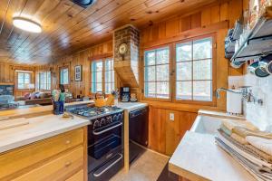 a kitchen with wooden walls and a stove at Knotty Pine Cabin in Joseph