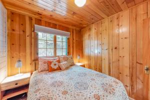 a bedroom with a bed in a wooden room at Knotty Pine Cabin in Joseph