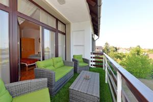 einen Balkon mit Korbstühlen und einem Tisch in der Unterkunft Blackbird Apartment in Balatonfüred