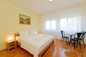 Schlafzimmer mit einem Bett, einem Tisch und Stühlen in der Unterkunft Blackbird Apartment in Balatonfüred