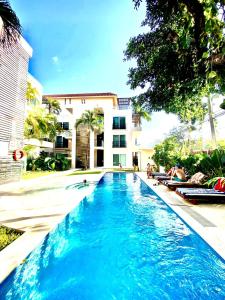 een zwembad voor een gebouw bij VIA TENDENZA VILLAS in Playa del Carmen