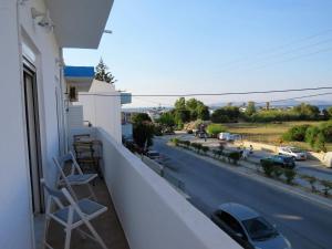 a balcony with chairs and a view of a street at Kyriakos Apartment in Mastichari