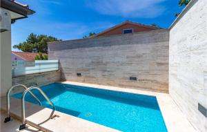 a swimming pool in front of a brick wall at Beautiful Apartment In Crikvenica With Wifi in Crikvenica