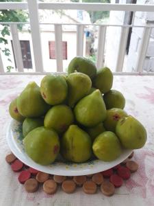 a plate of green pears on a table at Apartman Milanko in Muškovci +60 photos