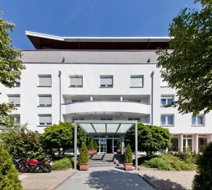 an external view of a white building at Novum Hotel Aviva Leipzig Neue Messe in Leipzig