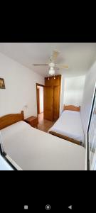 a bedroom with two beds and a ceiling at Bonito apartamento con terrazas y aparcamiento. in Son Bou
