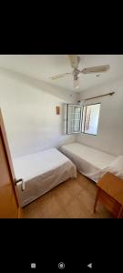 a bedroom with two beds and a window at Bonito apartamento con terrazas y aparcamiento. in Son Bou