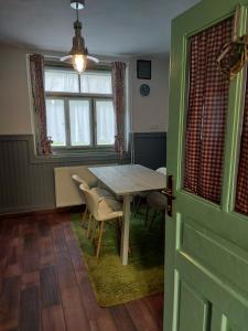 een eetkamer met een tafel en stoelen en een deur bij Pr' Šovarjo in Zgornje Gorje