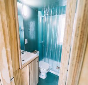 niebieska łazienka z toaletą i umywalką w obiekcie Loyca Eco-Tiny House w mieście Balneario El Condor