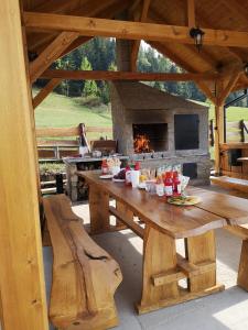 una mesa de picnic de madera en un pabellón con chimenea en Domki na Zagroniu en Koninki