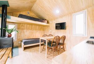 Pokój ze stołem i krzesłami oraz łóżkiem piętrowym w obiekcie Loyca Eco-Tiny House w mieście Balneario El Condor