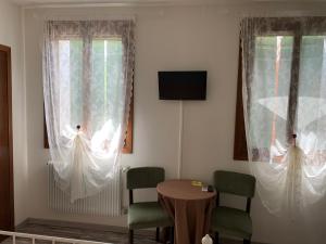 Zimmer mit 2 Stühlen, einem Tisch und 2 Fenstern in der Unterkunft Agriturismo Ca' Alleata in Caorle