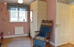 um quarto com uma cadeira azul e uma janela em Lovely Home In Grdd With Sauna em Gräddö