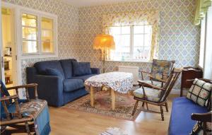 a living room with a blue couch and a table at Lovely Home In Gräddö With Sauna in Gräddö