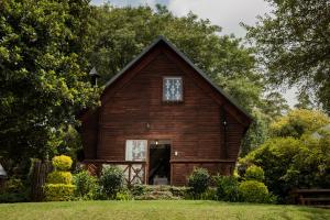 a large wooden barn with a door in a yard at Viewpoint - Cabin 2 in Haenertsburg