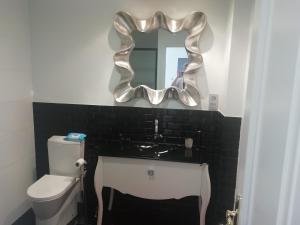 ein Badezimmer mit Waschbecken und Spiegel in der Unterkunft Céntrico y amplio piso con plaza parking in Cangas