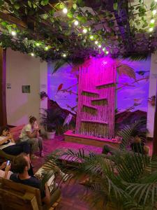 a group of people sitting in a room with a pink stage at ADVENTURE Hostel in San Gil