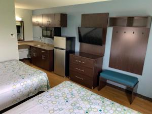 a hotel room with two beds and a kitchen at HomeTowne Studios by Red Roof Battle Creek in Battle Creek