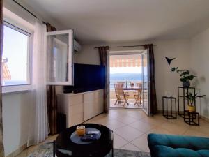 a living room with a view of the ocean at Apartment Teleferica Rabac in Rabac