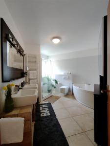 a bathroom with two sinks and a bath tub and a tubermott at Apartment Teleferica Rabac in Rabac