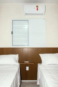 2 Betten in einem Zimmer mit Fenster in der Unterkunft Pousada Riviera - Praia de Lagoa do Pau in Coruripe