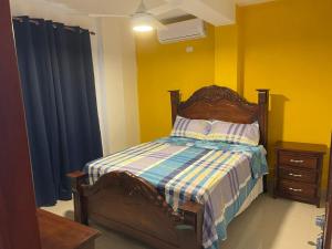 1 dormitorio con 1 cama con pared azul y amarilla en Hotel Gazcue, en Santo Domingo