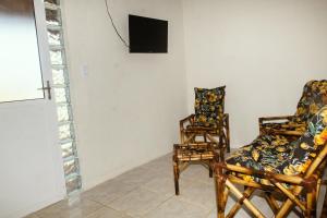 2 sillas y TV en una habitación en Pousada Riviera - Praia de Lagoa do Pau, en Coruripe