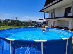 a man and a boy standing in a swimming pool at Willa Bafijówka in Groń