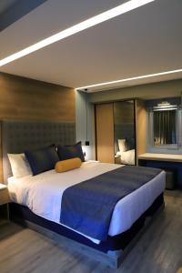 1 dormitorio con 1 cama grande con manta azul en ALIA INN BOUTIQUE, en Ciudad de México