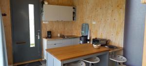 a small kitchen with a table and a counter at Tiny house het Polderhuisje in Streefkerk