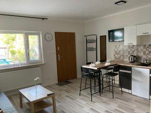 a kitchen with a table and chairs in a room at Apartamenty Zarzecze in Augustów