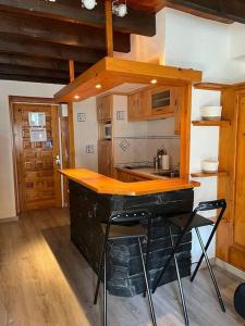 a kitchen with a counter and some stools in it at Envalira Vacances - Etoile duplex ideal familia con vista a pistas in Pas de la Casa