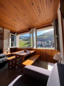 uma sala de estar com uma mesa e uma grande janela em Envalira Vacances - Etoile duplex ideal familia con vista a pistas em Pas de la Casa